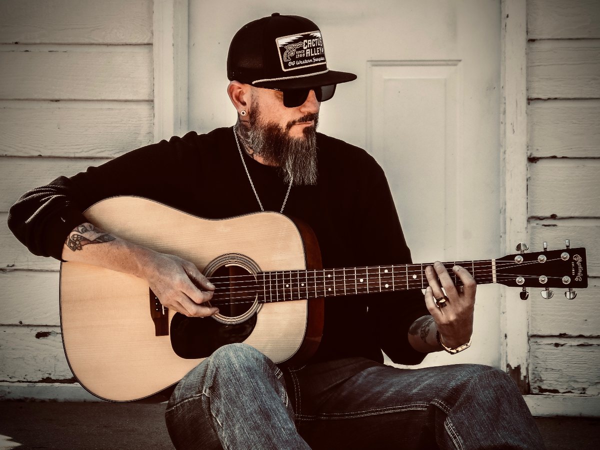 Troy Starr playing acoustic guitar
